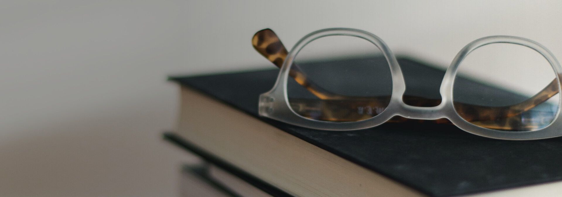 Brille auf Bücherstapel.