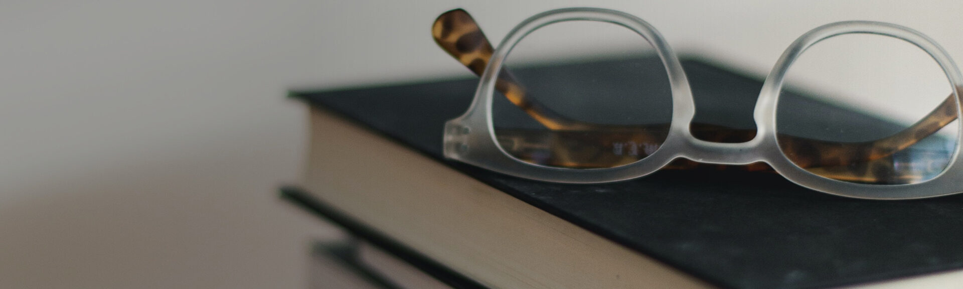 Brille auf Bücherstapel.